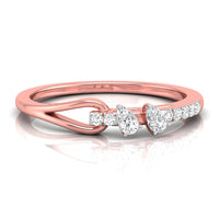 A rose gold ring with a unique twisted band design and a row of clear gemstones featuring pear and round-cut diamonds, set against a clean white background with a soft reflection.