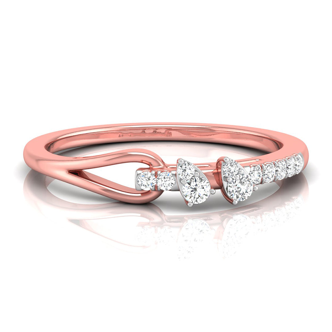 A rose gold ring with a unique twisted band design and a row of clear gemstones featuring pear and round-cut diamonds, set against a clean white background with a soft reflection.