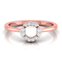 A rose gold ring with a circular halo design featuring small clear stones around an open center, shown on a clean white background with a soft reflection.