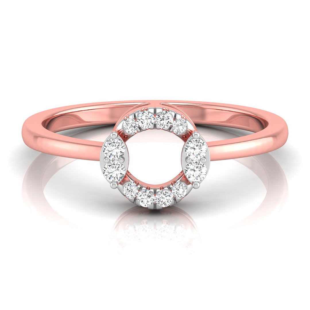 A rose gold ring with a circular halo design featuring small clear stones around an open center, shown on a clean white background with a soft reflection.