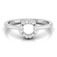 A silver-toned ring featuring a circular halo design with small clear gemstones around a larger open center, shown on a clean white background with a soft reflection. white gold
