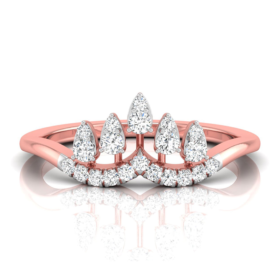 A rose gold ring with a crown-like top featuring pear-cut and round diamonds, shown on a clean white background with a soft reflection below.